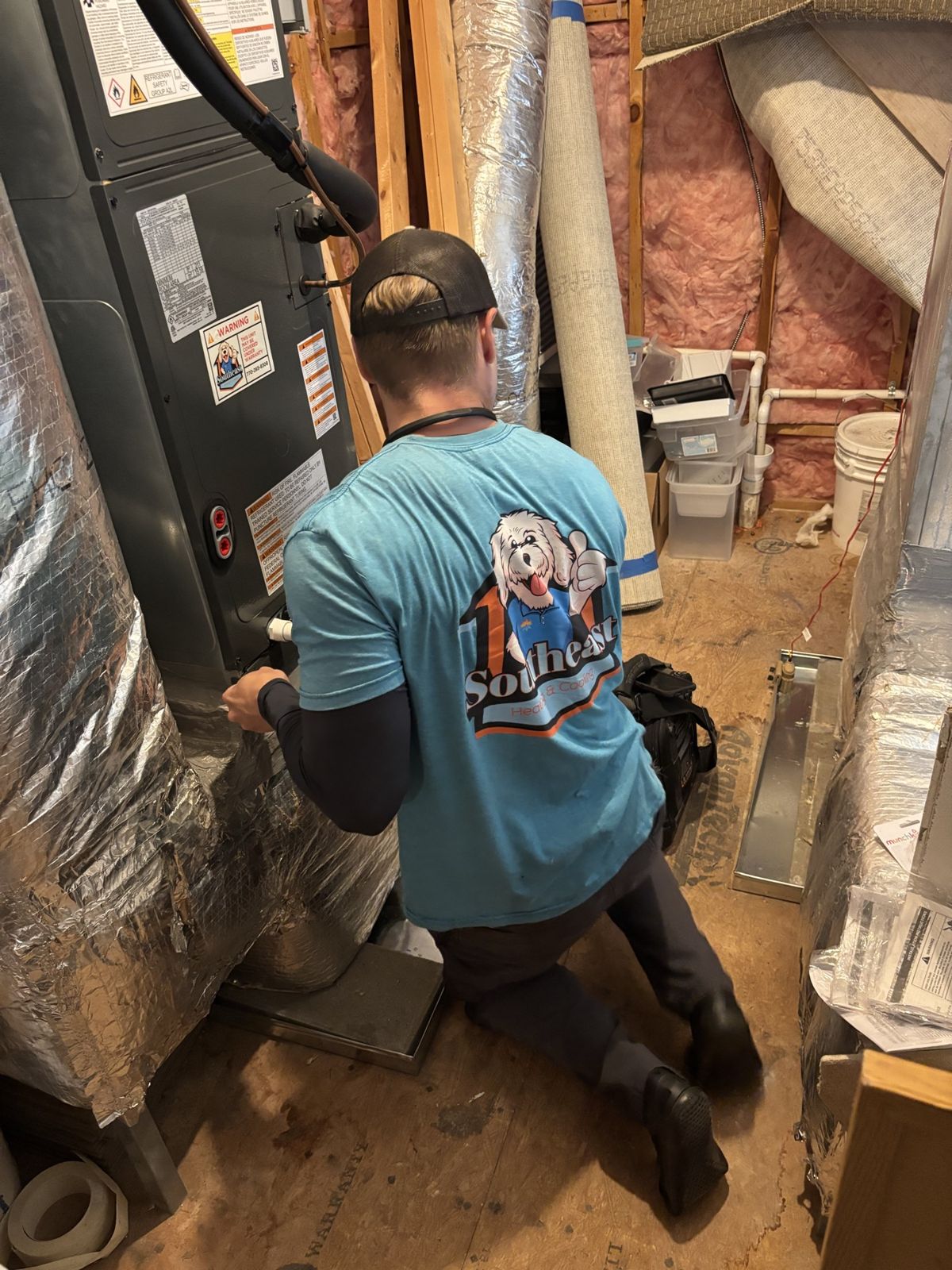 Technician servicing an attic air handler