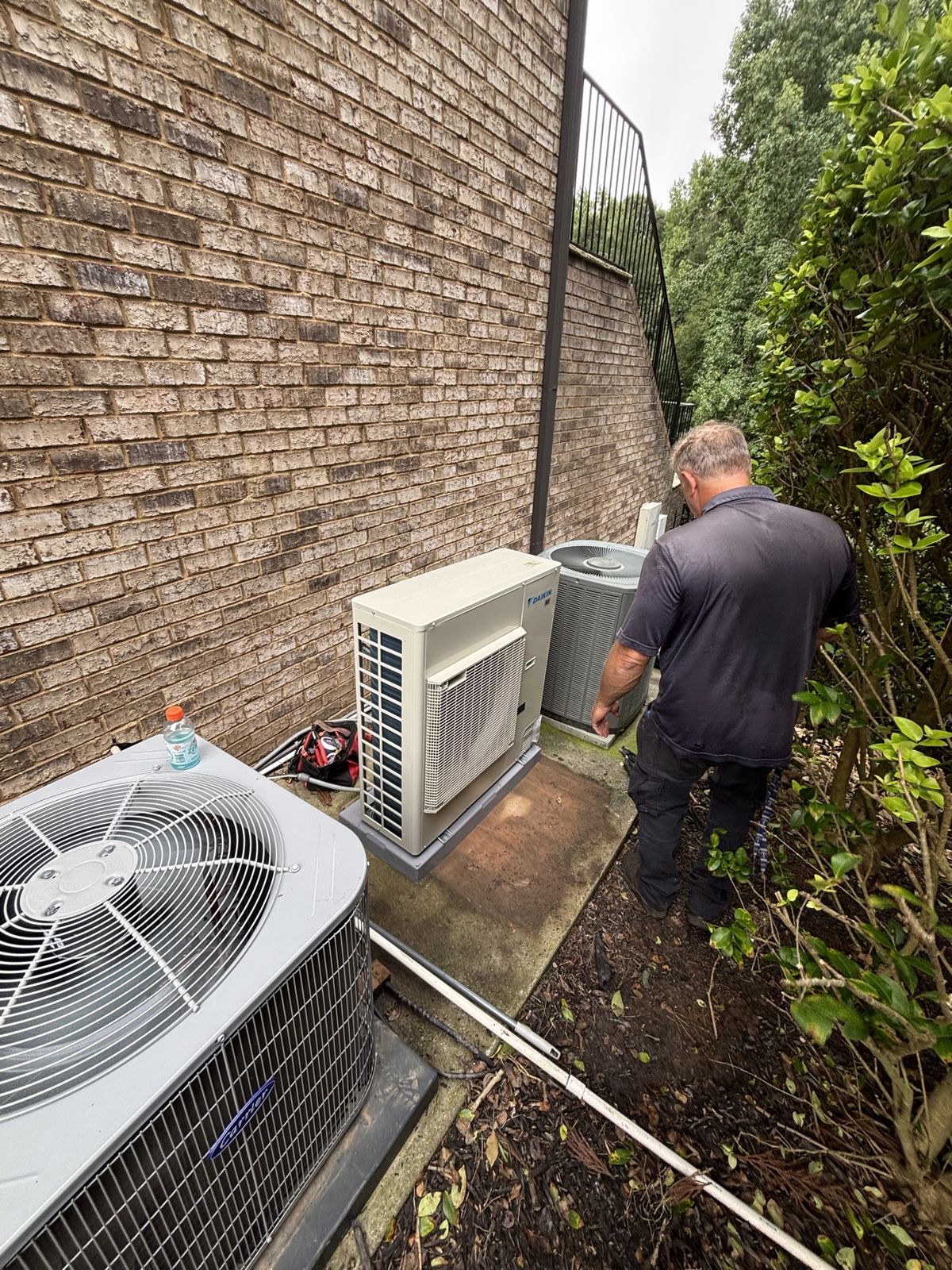 New heat pump condenser set on its pad outside a customer's home