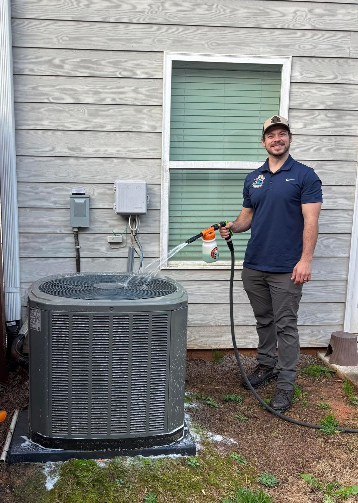 Southeast technician cleaning a condenser coil