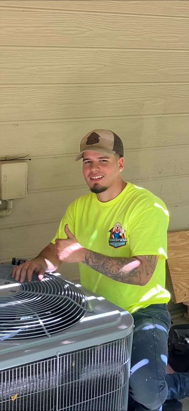Southeast technician beside an outdoor unit